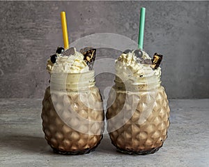 Chocolate milkshake with ice cream, whipped cream, berries, cookies, and waffles, served in a glass mason jar