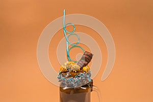 Chocolate milkshake with whipped cream, cookies, waffles, served in glass mason jar.