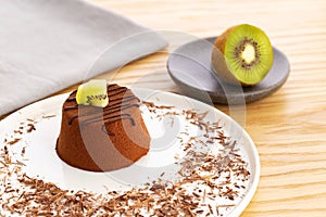 Chocolate Moelleux cake or molten cake, with kiwi fruit, over a wooden background