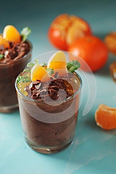 Chocolate mousse dessert with tangerines in glasses