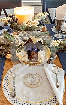 Chocolate mousse dessert and whipped cream with gold dust on a fancy crystal glass