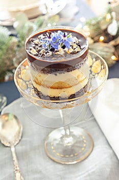 Chocolate mousse dessert and whipped cream with gold dust on a fancy crystal glass dish