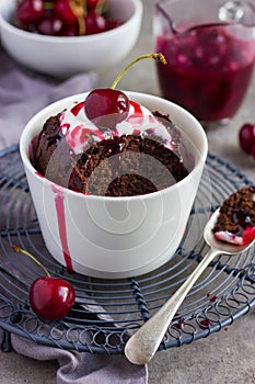 Chocolate muffin with cream and cherry sauce in a ramekin