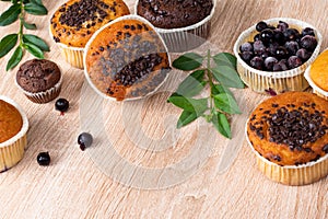 Chocolate muffin and nut muffin, homemade bakery on dark background. Muffin with blueberries on a wooden table.