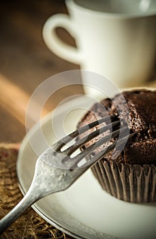 Chocolate muffin on wooden background, morning still life