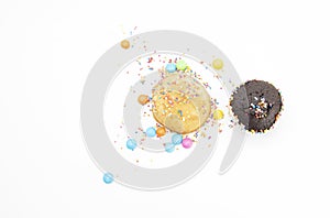 Chocolate muffin and yellow muffin cupcake design by colorful sprinkle isolated on white background, top view