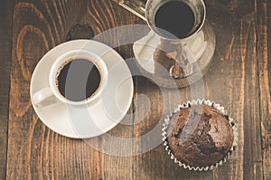 chocolate muffins, coffee cup and turks/ chocolate muffins, coffee cup and turks on a wooden background, top view