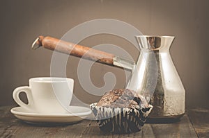 chocolate muffins, coffee cup and turks/ chocolate muffins, coffee cup and turks on a wooden dark background