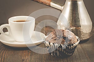 chocolate muffins, coffee cup and turks/chocolate muffins, coffee cup and turks on a wooden dark table, selective focus