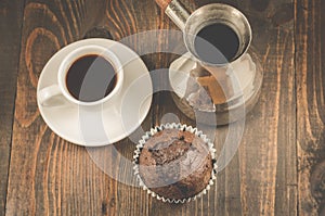 chocolate muffins, coffee cup and turks/chocolate muffins, coffee cup and turks on a wooden dark table, top view