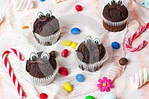 Chocolate muffins with edible eyes and colorful bonbons