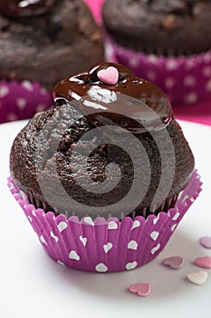 Chocolate muffins with melted chocolate and heart topping