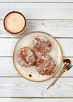 Chocolate muffins with nutmeg and cinnamon eggnog on a wooden background, cozy breakfast concept, advertising for a cafe or bakery