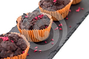 Chocolate muffins on slate plate isolated on white