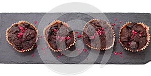 Chocolate muffins on slate plate isolated on white