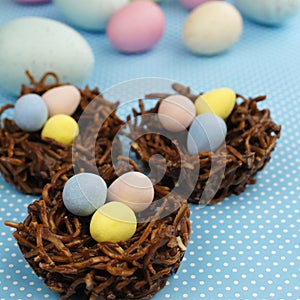 Chocolate nests filled with Easter eggs on blue