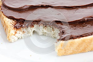Chocolate nut spread on sliced white bread.