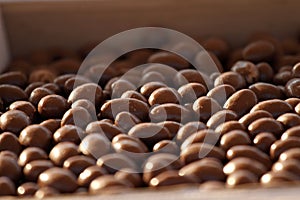 Chocolate nuts. Nuts in chocolate for dessert. Milk chocolate candies. Chocolate background texture.
