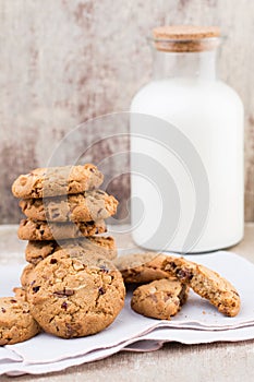 Chocolate oatmeal chip cookies with milk on the rustic wooden ta