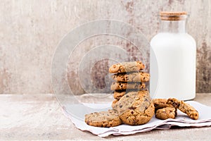 Chocolate oatmeal chip cookies with milk on the rustic wooden ta