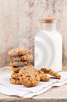 Chocolate oatmeal chip cookies with milk on the rustic wooden ta