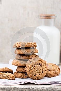 Chocolate oatmeal chip cookies with milk on the rustic wooden table