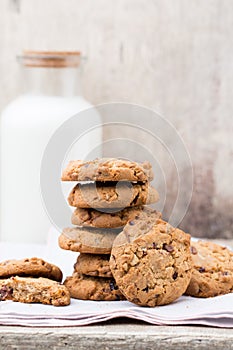 Chocolate oatmeal chip cookies with milk on the rustic wooden table