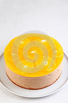 Chocolate-orange mousse cake with biscuit base, jelly and orange circles. Whole homemade cheesecake. Traditional holiday dessert.