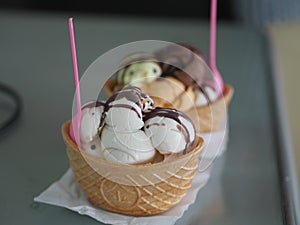 Chocolate, orange Thai tea, coconut milk ice cream in a crispy waffle cup on the mirror table