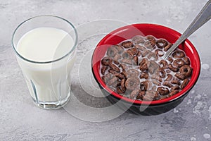 Chocolate organic breakfast cereals and glass with milk on table