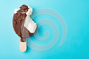 Chocolate outer ice cream with some bites on blue background