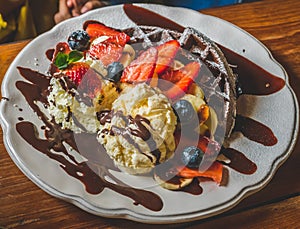 Chocolate Pancakes with banana, strawberry, blueberry, whipping cream and vanilla ice cream, icing sugar, brownies and chocolate s