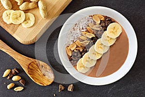 Chocolate, peanut-butter, banana, smoothie bowl downward scene on slate