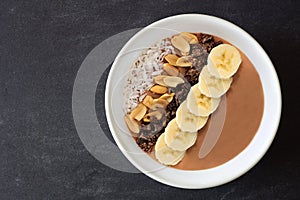 Chocolate, peanut-butter, banana, smoothie bowl on slate