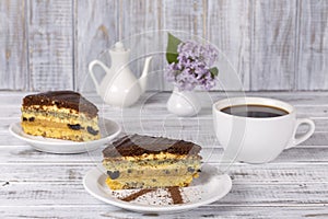 Chocolate piece of cake from biscuit dough with poppy seed, prune and walnuts and cup of coffee