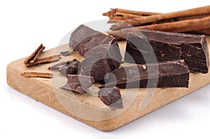 Chocolate pieces and cinnamon on a wooden board photo