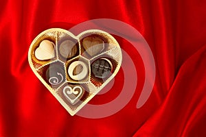 Chocolate pralines in golden heart shape box photo