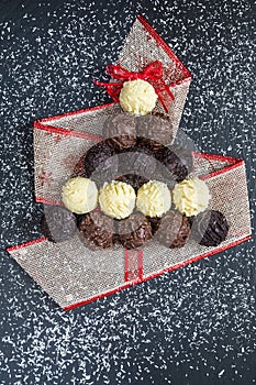 Chocolate pralines shape Christmas tree on black