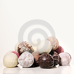 Chocolate pralines or truffles in front of white background with