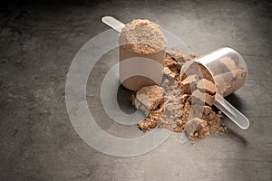 Chocolate protein powder in scoops. Food supplement, nutrition