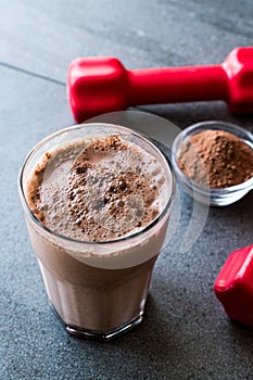 Chocolate Protein Shake Smoothie with Whey Protein Powder and Red Dumbbells