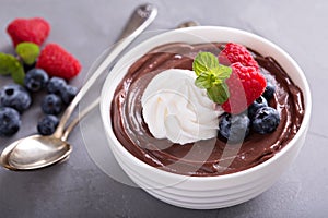 Chocolate pudding with whipped cream and berries photo
