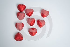 Chocolate red heart sweets in the form of the letter N for Valentine`s Day on a white background