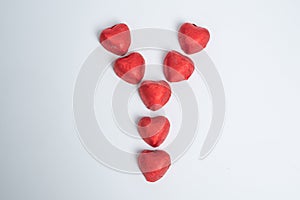 Chocolate red heart sweets in the shape of the letter Y for Valentine`s Day on a white background