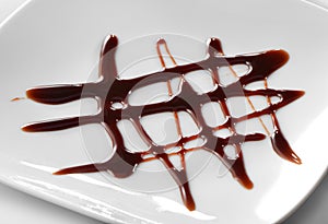 Chocolate sauce decoration on white plate