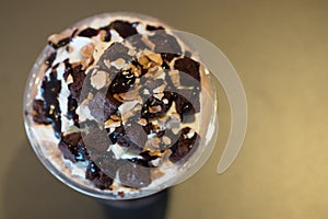 Chocolate sauce whipped cream nut and brownies on top iced drink