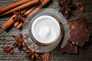 Chocolate skin treatment. Cosmetic jar with lotion, cocoa, anise, cinnamon sticks.