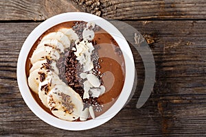 Chocolate smoothie bowl with banana, chia seeds and almond chips