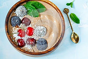 Chocolate smoothie bowl with cherry, mint and energy balls.