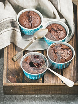 Chocolate souffle in blue individual baking cups in wooden tray